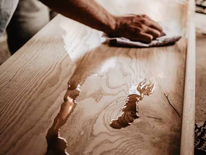 Hand wiping a finish onto a wooden surface