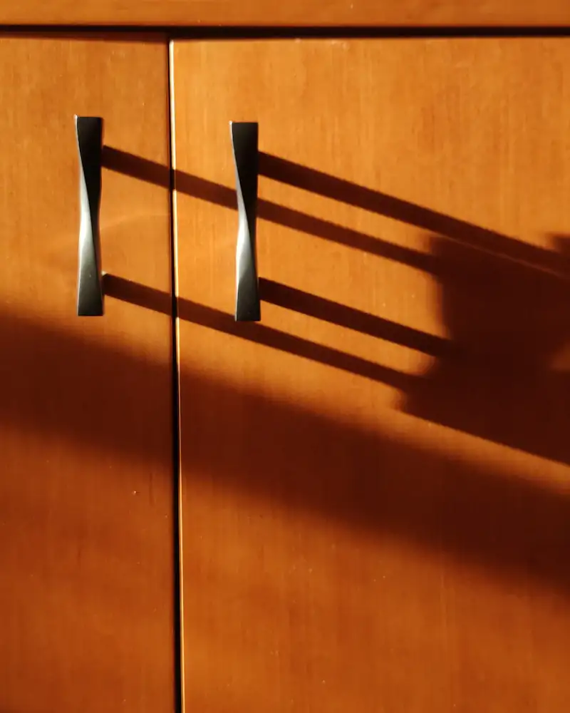Metal handle on a warm wooden cabinet door