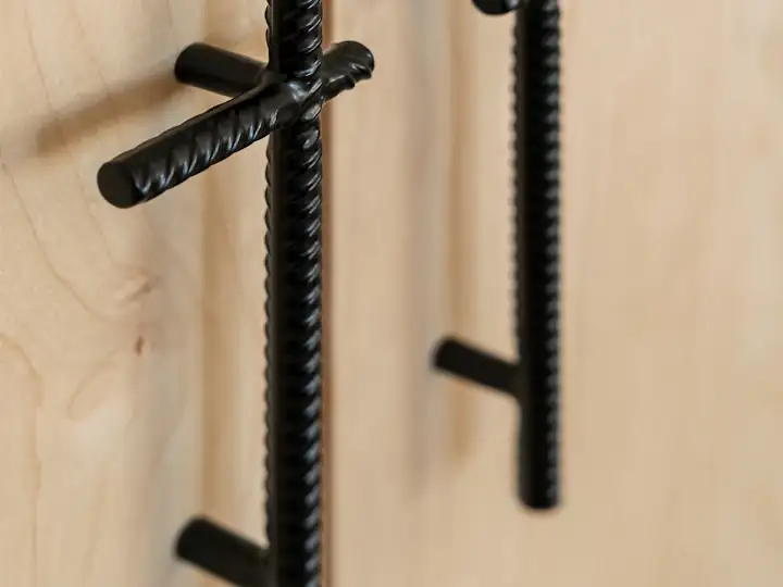 Matte black cabinet handles mounted on light wooden doors